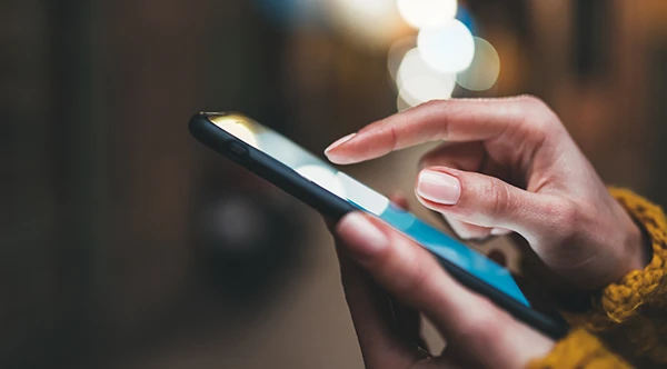 Close up of slender Black hands scrolling through a smart phone